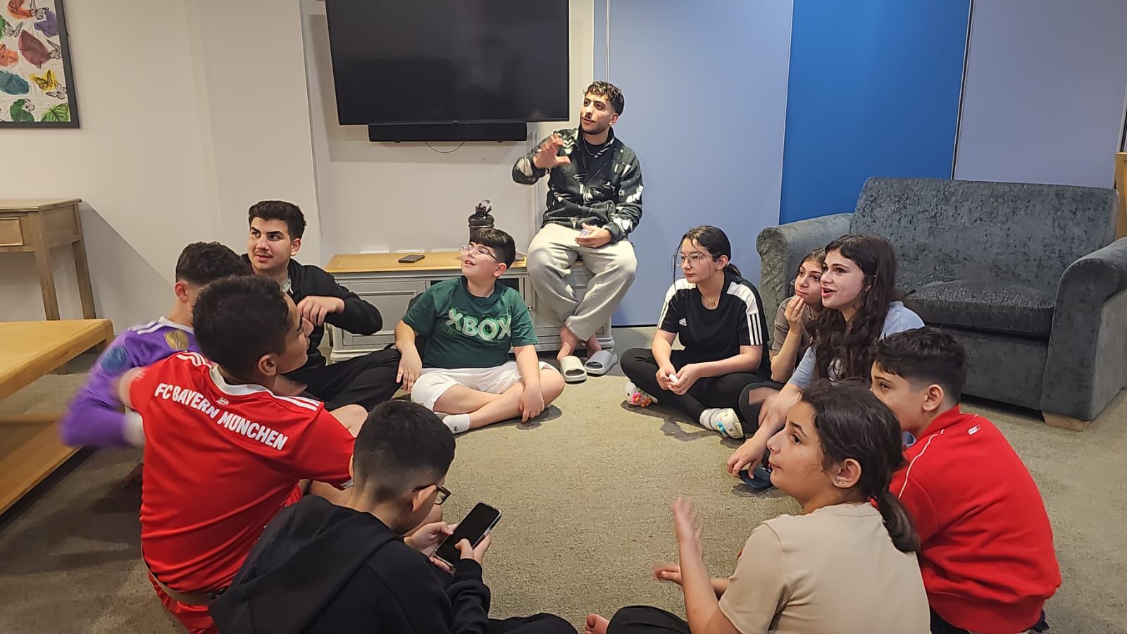 A speaker talking with a group of students at a Kidsology session